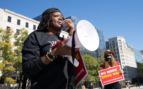 Women on city sidewalk with signs, No More Drug War