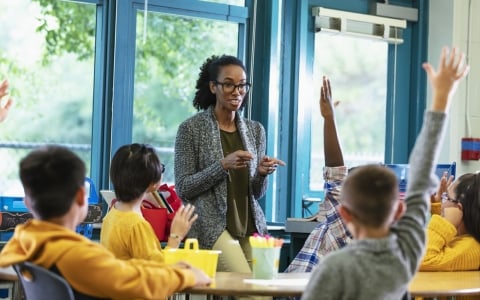 Smiling teacher facing her grade school students - ELSF