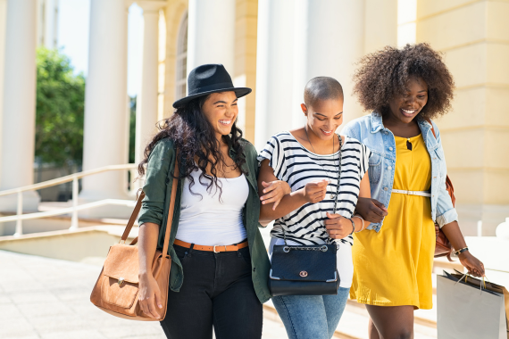 Three smiling women linking arms