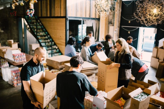 10-15 people pack boxes as part of a volunteer project.