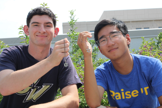 Two young men smiling with their Magen David necklaces