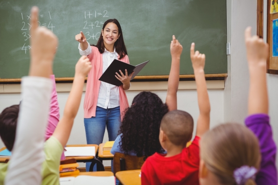 teacher in front of classroom - ed trust
